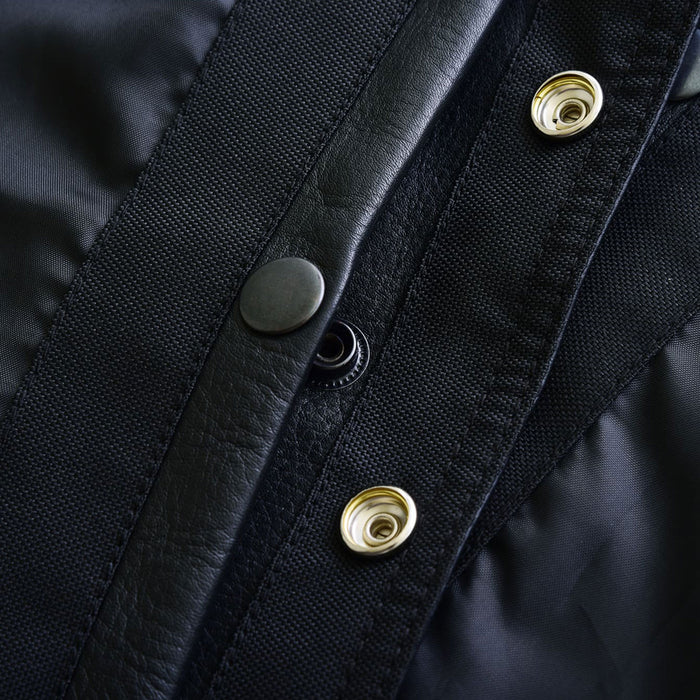 Close-up of the genuine brass snaps with Leatherick logo, used for vest closure and chest pocket flaps.