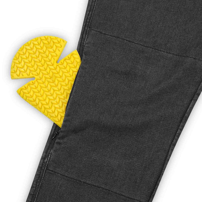 A close-up view of the external knee protector pocket on men's black single-layer motorcycle riding jeans with a yellow protective armor insert partially visible.